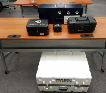 Three storage containers of different sizes and blue lightbox (used to test efficiency of three lightbulbs)